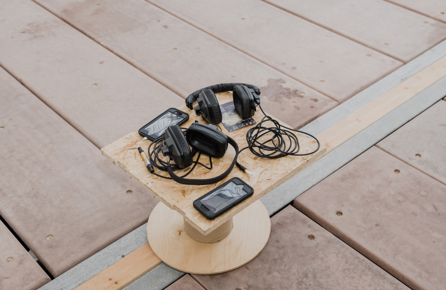 detail of heaphones and iphones on a diy table